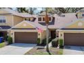 Charming yellow townhome with two-car garage, an American flag, and tidy landscaping at 8539 Sandpiper Ridge Ave, Tampa, FL 33647