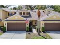 Townhome exterior features a two-car garage and a well-maintained lawn with an American flag at 8539 Sandpiper Ridge Ave, Tampa, FL 33647