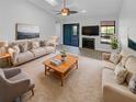 Bright living room featuring neutral decor, ceiling fan, fireplace, and sliding glass doors for ample natural light at 110 Lakeside Colony Dr, Tarpon Springs, FL 34689