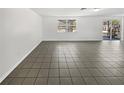 A spacious living room with neutral walls and tiled floors offers a blank canvas for your personal design at 3409 King Richard Ct, Seffner, FL 33584