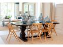 Elegant dining room with a dark wood table, light wood chairs, a neutral rug, and decorative glass vases at 1011 Signet, Apollo Beach, FL 33572