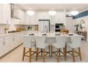 Spacious white kitchen featuring a large center island with seating, modern appliances, and pendant lighting at 1011 Signet, Apollo Beach, FL 33572