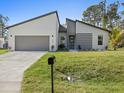 Well-manicured lawn enhances the curb appeal of this modern, one-story home with a two-car garage at 24299 Kingsway Cir, Punta Gorda, FL 33983