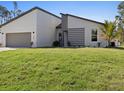 Well-manicured lawn and modern architectural design enhance the curb appeal of this home at 24299 Kingsway Cir, Punta Gorda, FL 33983