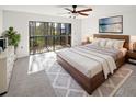 Bright bedroom features a sliding glass door to balcony and a decorative ceiling fan at 2108 Tarpon Landings Dr, Tarpon Springs, FL 34688