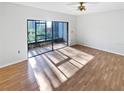 Bright living room featuring hardwood floors and access to screened patio at 2108 Tarpon Landings Dr, Tarpon Springs, FL 34688