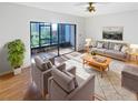 Bright living room with sliding glass doors, neutral decor, ceiling fan, and hardwood floors at 2108 Tarpon Landings Dr, Tarpon Springs, FL 34688