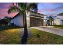 Property showcasing a dark garage door framed by stylish lighting and a pristine driveway at 24470 Kingsway Cir, Punta Gorda, FL 33983