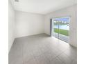Open living space offering tiled flooring, neutral paint and sliding door access to the backyard at 32100 Pop Ash Pl, San Antonio, FL 33576