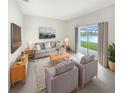 Inviting living room features neutral tones, stylish furniture, and a sliding glass door with scenic water view at 32100 Pop Ash Pl, San Antonio, FL 33576