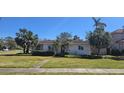Charming one-story home featuring a landscaped lawn, tiled roof, and mature palm trees at 515 Snell Isle Ne Blvd, St Petersburg, FL 33704