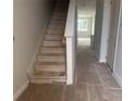View of the unfinished staircase with carpet removed and open access to the upper floor of the home at 7268 Deer Valley Circle, Tampa, FL 33635