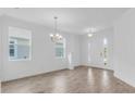 Bright living room featuring wood-look tile floors, elegant chandelier, and a freshly painted white interior at 1067 Signet, Apollo Beach, FL 33572