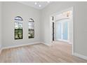 Bright living room with wood floors, two windows, and an open doorway at 5516 Madrigal Way, Apollo Beach, FL 33572