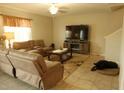 Inviting living room with plush sofas, a large TV, and a cozy rug creating a comfortable space at 14825 Crescent Rock Dr, Wimauma, FL 33598