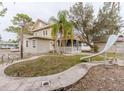 View of home with a small enclosed porch, slide, and a mature tree at 8226 36Th N Ave, St Petersburg, FL 33710
