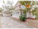 Side view of a two-story house with a detached garage and a concrete driveway at 8226 36Th N Ave, St Petersburg, FL 33710
