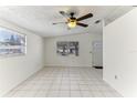 Bright living room with tiled floors, ceiling fan, and large windows offering ample natural light at 4046 Las Vegas Dr, New Port Richey, FL 34653
