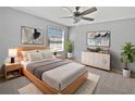 Bright main bedroom with a ceiling fan, stylish furnishings, and ample natural light from the window at 11406 Holmbridge Ln, Riverview, FL 33579