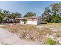 Shows a single-story home with brick accents, a small palm tree, and a carport on a sunny day at 1825 134Th St, Largo, FL 33778