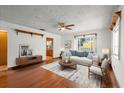 Bright living room with hardwood floors, a ceiling fan, and a window showcasing natural light at 8608 N 20Th St, Tampa, FL 33604