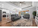 Bright living room featuring a tray ceiling, an open floor plan, and a large sliding glass door at 6191 Lenape Ln, North Port, FL 34291