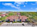 Overhead view of a condo complex surrounded by palm trees, lush landscaping, and a visitor parking lot at 5729 Baywater Dr # 5729, Tampa, FL 33615