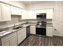 Bright kitchen features white cabinets, granite countertops, and stainless steel appliances at 11856 Throttle Pl, Gibsonton, FL 33534