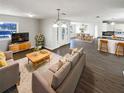 Open-concept living room with hardwood floors and a view into the kitchen and dining area at 4800 86Th N Ave, Pinellas Park, FL 33782