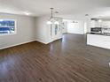 Open-concept living room with hardwood floors and view of front door and kitchen at 4800 86Th N Ave, Pinellas Park, FL 33782