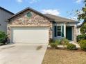 Attractive single-Gathering home with stone accents, an attached garage, and a neatly landscaped yard at 5139 Brickwood Rise Dr, Wimauma, FL 33598