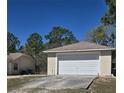 Two-car detached garage with concrete driveway and a neutral color palette at 12403 Snowy Egret Ave, Weeki Wachee, FL 34614