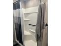 Clean and modern shower with white surround, shelving, and sleek black hardware at 15168 Chamberlain Blvd, Port Charlotte, FL 33953