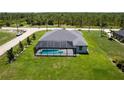 Aerial view of a beautiful home with a screened-in pool and surrounded by lush green grass at 291 Rotonda S Blvd, Rotonda West, FL 33947