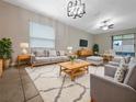 Bright living room featuring stylish furniture, decorative lighting, and a sliding door to the patio at 15729 Fort Island Pl, Sun City Center, FL 33573