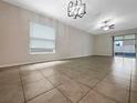 Spacious living room with tile flooring, modern lighting, and sliding glass doors for natural light at 15729 Fort Island Pl, Sun City Center, FL 33573