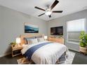 Cozy bedroom featuring a ceiling fan, large window, and stylish decor at 15729 Fort Island Pl, Sun City Center, FL 33573