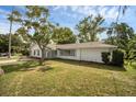 Beautifully landscaped lawn features mature trees surrounding the single-story home at 1937 N Highland Ave, Clearwater, FL 33755
