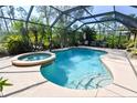 Screened-in swimming pool with hot tub and outdoor seating provides a relaxing backyard oasis at 5769 E Price Blvd, North Port, FL 34288