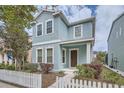 Charming blue two-story home with a white picket fence and well-maintained landscaping at 6160 Castleton Hollow Rd, Riverview, FL 33578