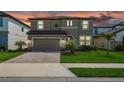 Beautiful two-story home with manicured lawn, paver driveway, two-car garage and tropical landscaping against a vibrant sunset at 12654 Oak Hill Way, Parrish, FL 34219