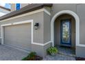 View of front door with decorative glass and sidelight, framed by an archway and lanterns at 12654 Oak Hill Way, Parrish, FL 34219
