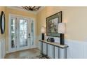 Bright foyer featuring a decorative glass door, console table with lamps, and stylish light fixture at 6237 Plateau Ct, Bradenton, FL 34203