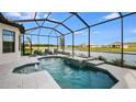 Screened in pool and spa overlooking the lake with two lounge chairs on the deck at 6237 Plateau Ct, Bradenton, FL 34203