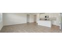Open concept living area with tile flooring, white walls and kitchen island at 31622 Malbec Ln, Brooksville, FL 34602