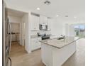 Open kitchen with granite countertops, stainless steel appliances, and island sink at 3561 Moscato Dr, Brooksville, FL 34602