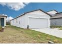 Side view of a single story house with a two-car garage and a well-kept lawn at 3652 Moscato Dr, Brooksville, FL 34602