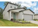 Inviting home with a two-car garage, covered entry, and lush landscaping enhancing curb appeal at 3824 Radiant Mountain Dr, Plant City, FL 33565