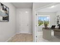 Inviting entryway featuring light wood floors and an open view to the home office with large window at 12963 Brookside Moss Dr, Riverview, FL 33579