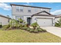 Attractive two-story home with a manicured lawn and a two-car garage with an appealing entrance at 12963 Brookside Moss Dr, Riverview, FL 33579